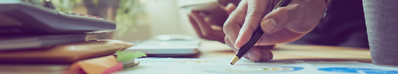 Close up of hand with a pen pointing at a graph.