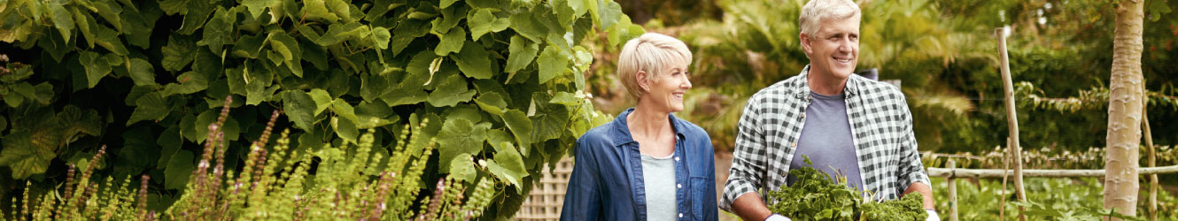 Mature couple walking through a garden.