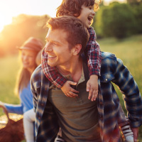 Mother with child on father's back outside having fun