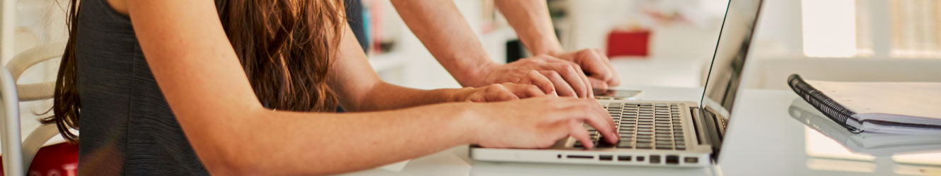 Close up of hands typing on a laptop.